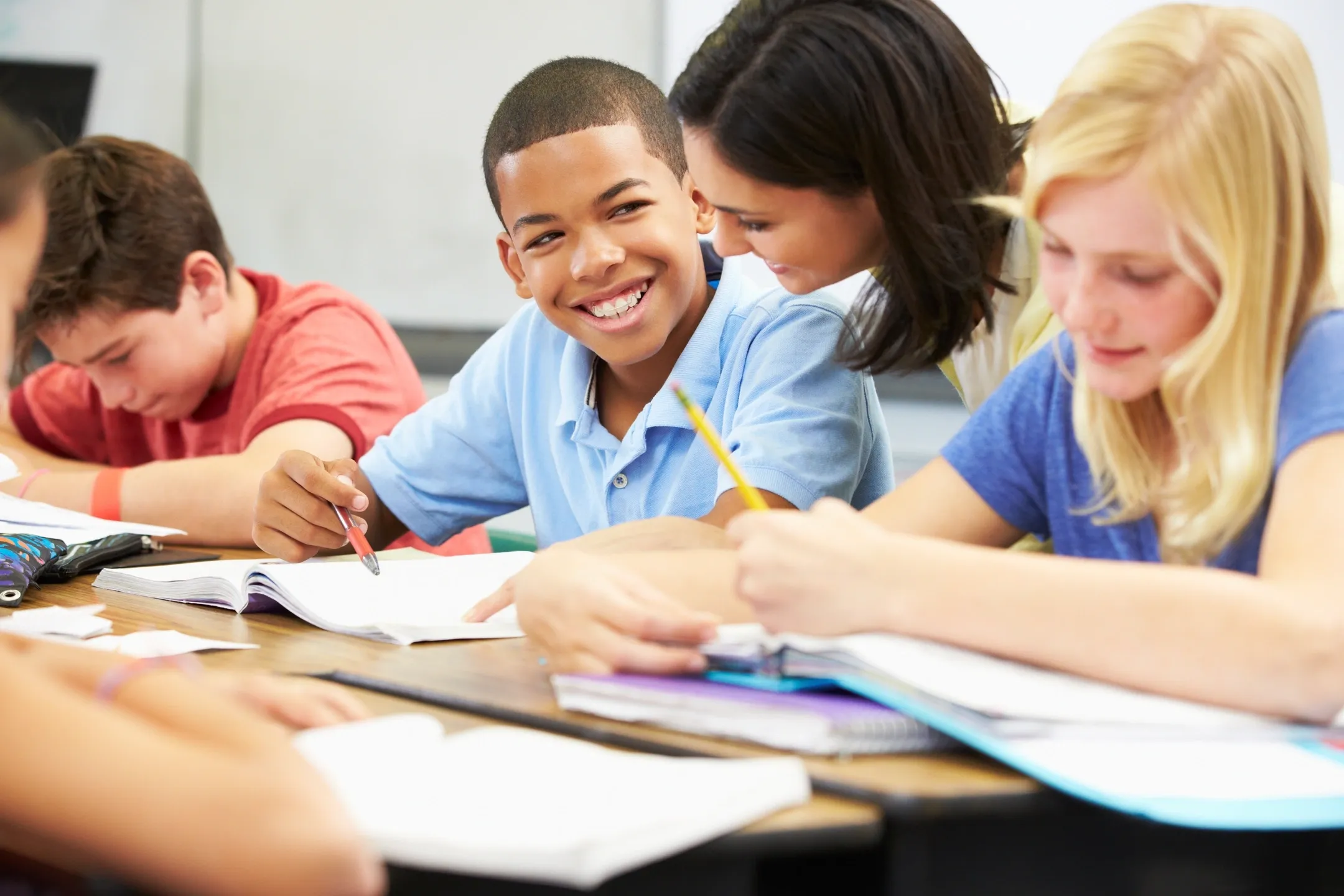 A group of students sitting at a table with papers.