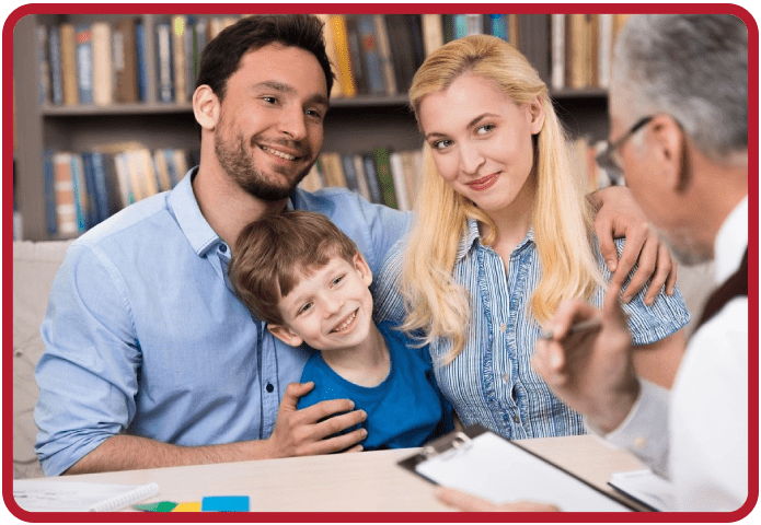 A family sitting at the table with books in front of them.