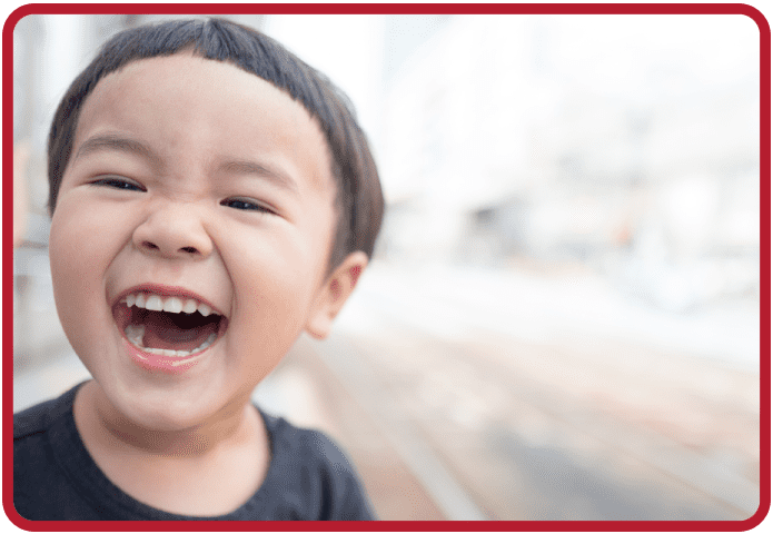 A young boy smiling with his mouth open.